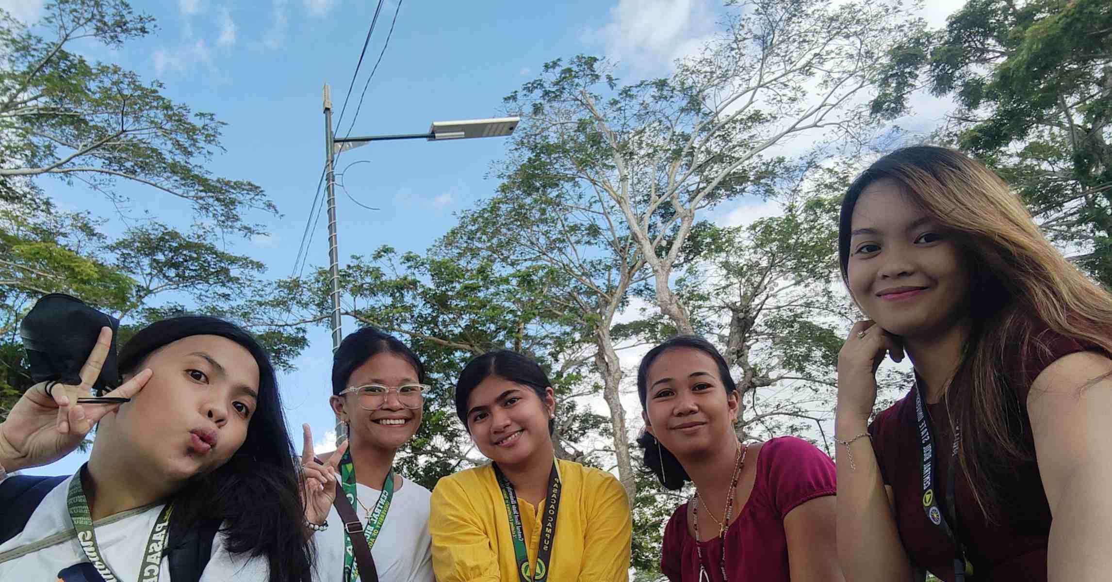 Nhóm bạn trẻ cùng chụp ảnh chung, cười tươi trong một buổi đi chơi ngoài trời