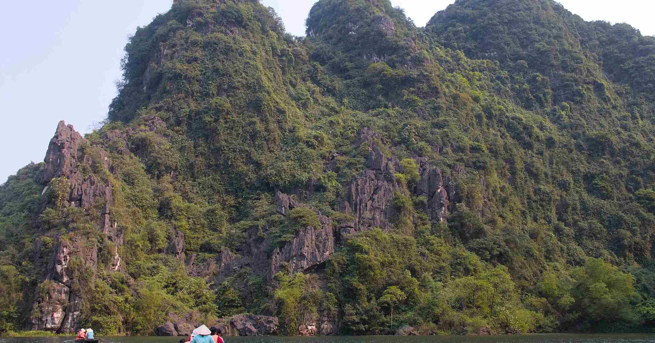 Nhóm du khách đi thuyền ngắm cảnh giữa núi đá Tràng An, Ninh Bình