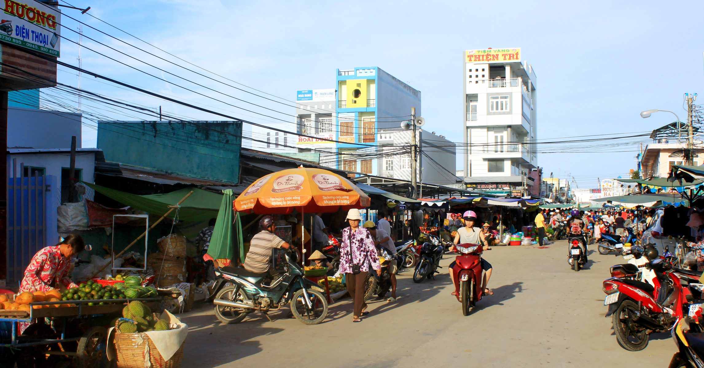 Chợ thị trấn Năm Căn, Cà Mau, buổi sáng với người dân buôn bán trái cây và xe máy qua lại