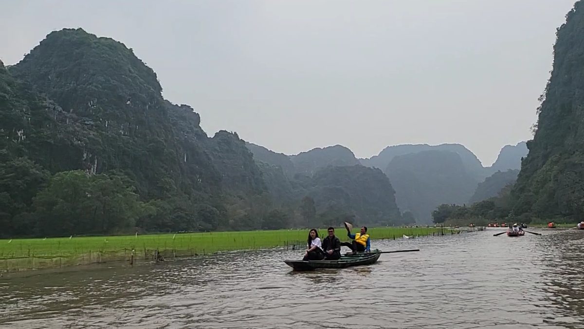 Người chèo thuyền nan chở khách trên sông giữa những dãy núi đá vôi ở Tam Cốc, Ninh Bình