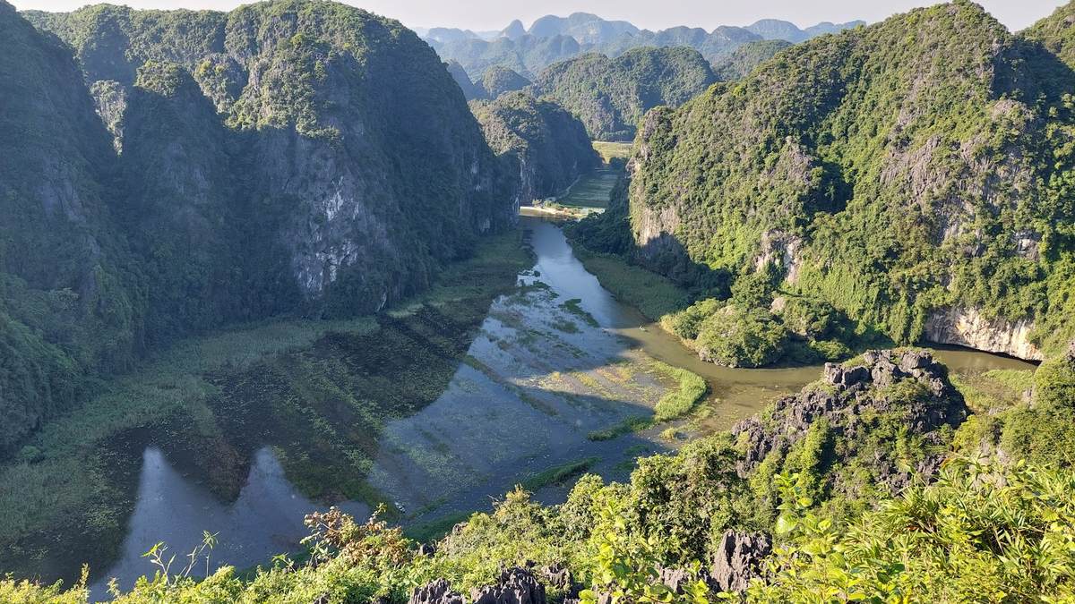 Toàn cảnh dòng sông uốn lượn giữa cánh đồng và núi đá vôi nhìn từ đỉnh Hang Múa, Ninh Bình